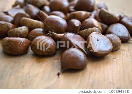 many chestnuts placed on a wooden table 106894858