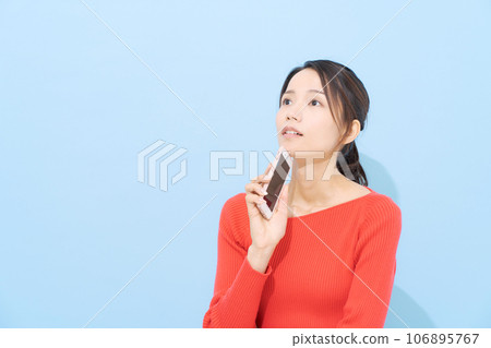 一個拿著智能手機、表情憂心忡忡的女人 106895767