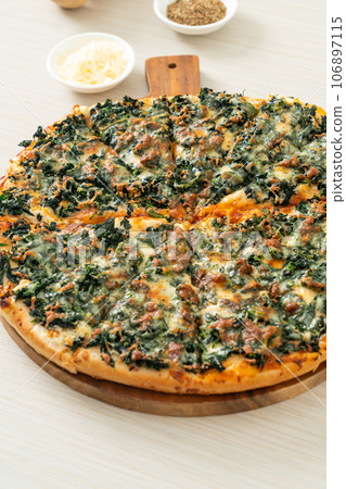 spinach and cheese pizza on wood tray 106897115