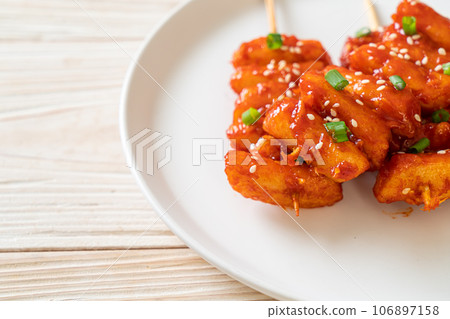 deep fried Korean rice cake (Tteokbokki) skewered with spicy sauce deep fried Korean rice cake (Tteokbokki) skewered with spicy sauce 106897158