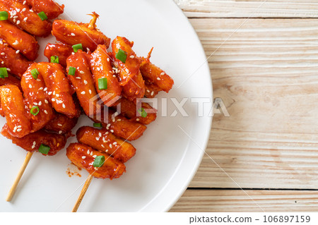 deep fried Korean rice cake (Tteokbokki) skewered with spicy sauce deep fried Korean rice cake (Tteokbokki) skewered with spicy sauce 106897159