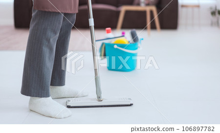 Maid using cleaner equipment in bucket plastic and mop to mopping and cleaning dust on the floor Maid using cleaner equipment in bucket plastic and mop to mopping and cleaning dust on the floor 106897782