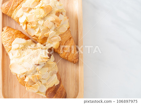 croissant with cream and almonds 106897975