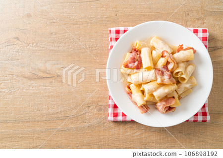 spaghetti rigatoni pasta with white sauce and bacon 106898192
