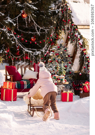 Little Girl Sledding Near the Christmas Tree Little Girl Sledding Near the Christmas Tree 106898367