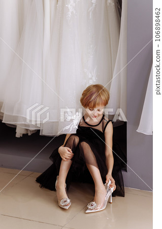 Little girl in a black evening dress in a clothing boutique 106898462