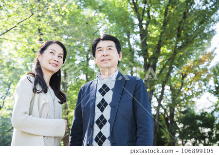 A middle-aged couple having a date in a fresh green park A middle-aged couple having a date in a fresh green park 106899105