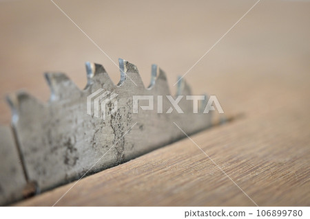 sharp metal saw on wood plank texture background, construction machine 106899780