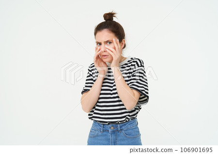 Image of woman looking scared, apalled by something shocking, standing over white background Image of woman looking scared, apalled by something shocking, standing over white background 106901695