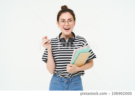 Student lifestyle and people concept. Portrait of young woman in glasses, teacher or college girl with books and study material, posing over white background 106902000
