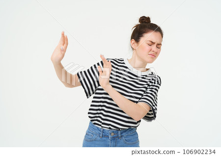 Portrait of woman looking disgusted, expressing dislike and aversion, raising hands to block something, rejecting offer, refusing, standing over white background Portrait of woman looking disgusted, expressing dislike and aversion, raising hands to block something, rejecting offer, refusing, standing over white background 106902234