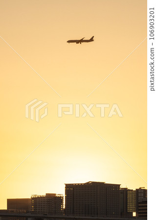 Airplane flying over the city at sunset Airplane flying over the city at sunset 106903201