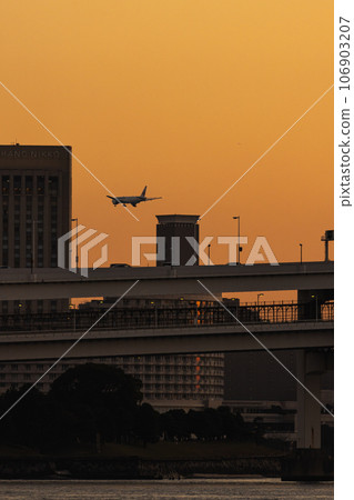 日落時飛機飛過城市上空 日落時飛機飛過城市上空 106903207