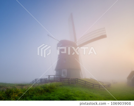 Landscape with windmill during fog. Holland. Dawn during a thick fog.  106903908