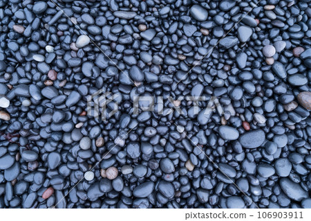 Gray pebbles as a background. Round stones on the beach. Photography for design.  106903911