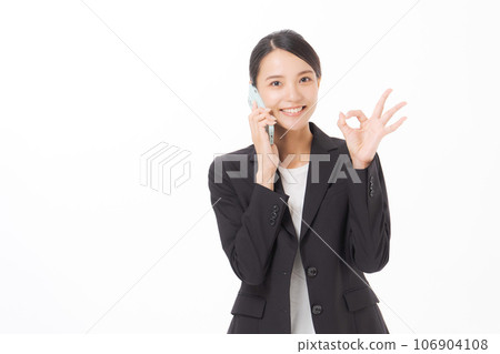 A woman in a suit making a phone call 106904108