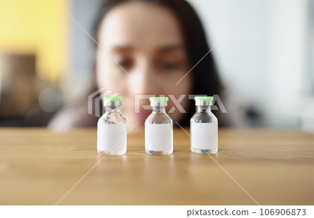 Woman looks at vaccine bottle and decides which one to choose 106906873