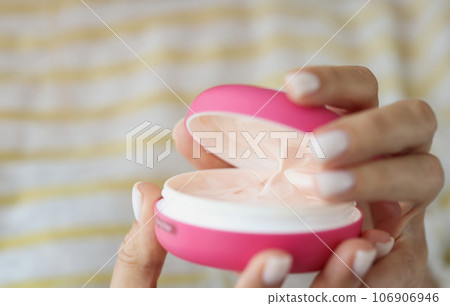Hands of beautiful well-groomed woman with pink jar of cream Hands of beautiful well-groomed woman with pink jar of cream 106906946