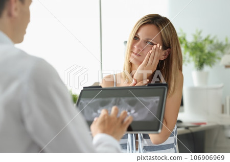 Female patient with acute toothache at doctor appointment with X-ray image 106906969