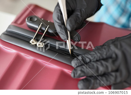 Thief with gloves tries to open suitcase with handle Thief with gloves tries to open suitcase with handle 106907015