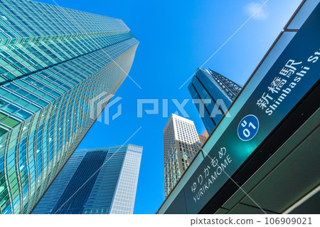 Tokyo cityscape in Japan September. View of the Shiodome office complex and Yurikamome Shinbashi Station under the blue sky Tokyo cityscape in Japan September. View of the Shiodome office complex and Yurikamome Shinbashi Station under the blue sky 106909021