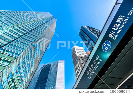 Tokyo cityscape in Japan September. View of the Shiodome office complex and Yurikamome Shinbashi Station under the blue sky Tokyo cityscape in Japan September. View of the Shiodome office complex and Yurikamome Shinbashi Station under the blue sky 106909024