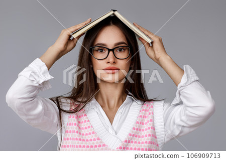 with book on head on grey background 106909713