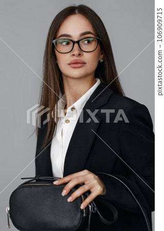 woman with handbag in black blazer isolated on grey background 106909715