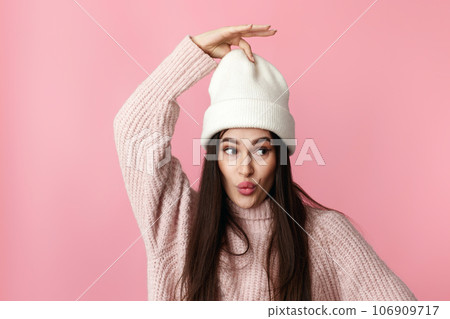 funny woman in white hat, sweater grimacing with lips 106909717
