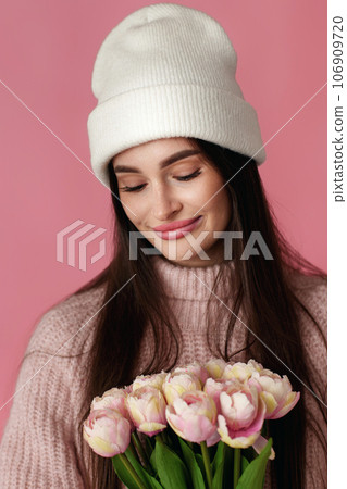 pretty woman in white hat, sweater holding bouquet of tulip pretty woman in white hat, sweater holding bouquet of tulip 106909720