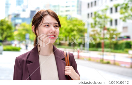 Business woman commuting in front of an office building Business woman commuting in front of an office building 106910642