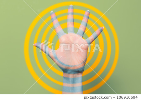A woman's hand with outstretched fingers. Green background with yellow rings. Close up. Concept of hypnosis, influence, and psychology A woman's hand with outstretched fingers. Green background with yellow rings. Close up. Concept of hypnosis, influence, and psychology 106910694