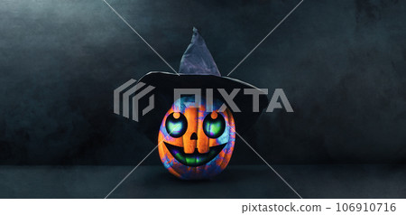 Banner with carved Jack-o-lantern. A decorated multicolored pumpkin in a black witch's hat on black background with copy space 106910716