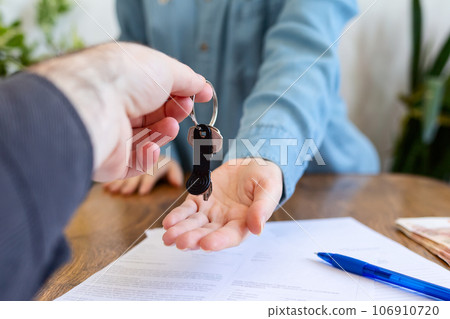 World leasing day concept. Realtor gives the keys to the new owner. Close-up of hands. Rental and purchase of real estate World leasing day concept. Realtor gives the keys to the new owner. Close-up of hands. Rental and purchase of real estate 106910720