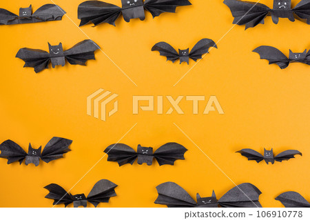 Bats made of paper are arranged on an orange background. Copy space. Flat lay. The concept of Halloween, and holiday decorations 106910778