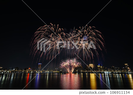 Colorful fireworks of various colors over night sky with    reflection in water   106911134