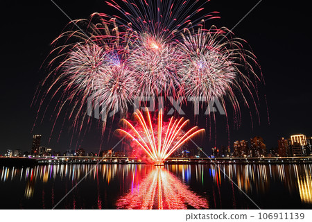 Colorful fireworks of various colors over night sky with    reflection in water   106911139