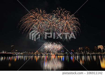 Colorful fireworks of various colors over night sky with    reflection in water   106911142