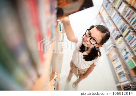 A girl choosing a book 106912014