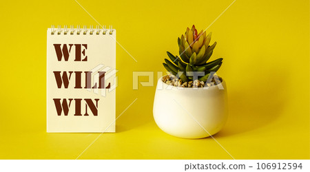 We Will Win, text on notepad, yellow background 106912594