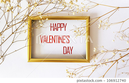 Happy Valentine's Day written on a gold frame framed with dry white flowers on a white background Happy Valentine's Day written on a gold frame framed with dry white flowers on a white background 106912740