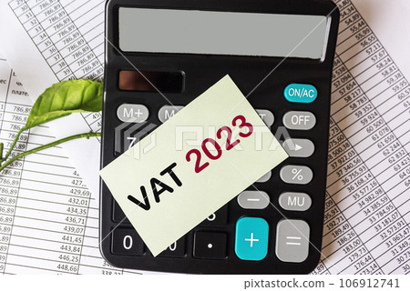 Calculator, documents and reports and a sticker with the text VAT 2023 Calculator, documents and reports and a sticker with the text VAT 2023 106912741