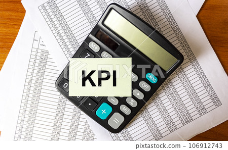 KPI abbreviation Key Performance Indicator Desktop with financial statements and calculator 106912743