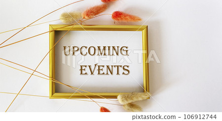 Upcoming event message on a gold frame and white background with dry flowers. Upcoming event message on a gold frame and white background with dry flowers. 106912744
