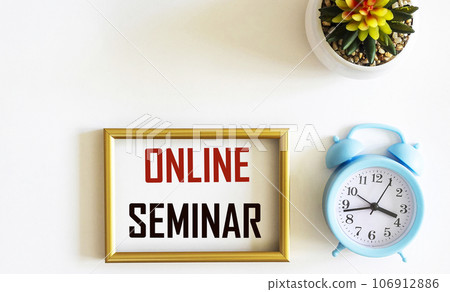 In a photo frame with the text Online Seminar, isolated on white with alarm clock and cactus. 106912886
