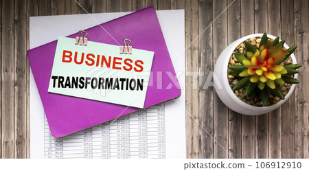 Business transformation text is written on a note that lies on a notebook and contracts  106912910