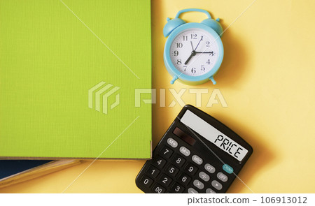 The word PRICE written on a calculator and a yellow background. Along with folders The word PRICE written on a calculator and a yellow background. Along with folders 106913012