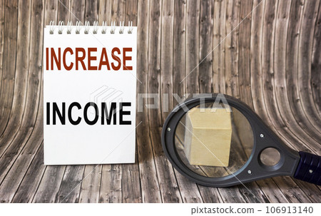 Increase income, the text is written on a notebook. Nearby a magnifying glass with a plus sign Increase income, the text is written on a notebook. Nearby a magnifying glass with a plus sign 106913140