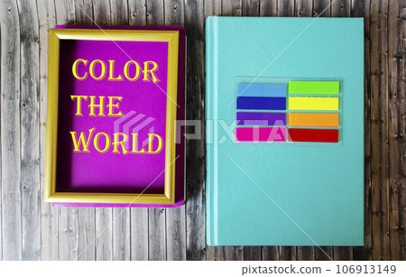next to a colored notebook and colorful stickers on a wooden table 106913149