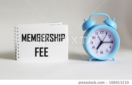 On notepad text about membership fee, business concept image on white background with alarm clock 106913210